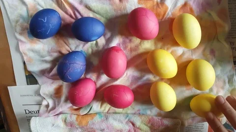 Painted easter eggs, blue, pink, yellow close up from above, hand takes egg Vídeos de archivo 76280109