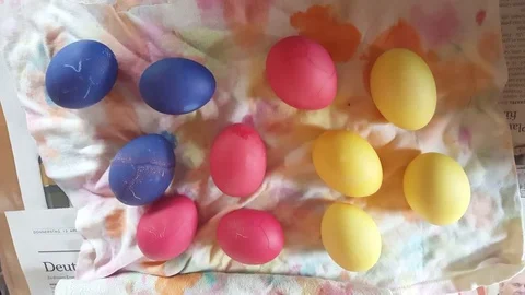 Painted easter eggs, blue, pink, yellow, dry on cloth, close up from above 스톡 동영상 76281087