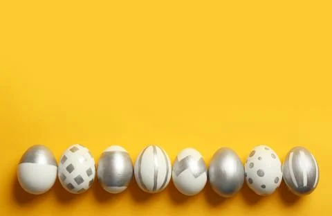 Painted Easter eggs on color background, top view with space for text 스톡 사진