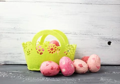 Painted Easter Eggs  in decorated green basket on wooden table. Stock Photos