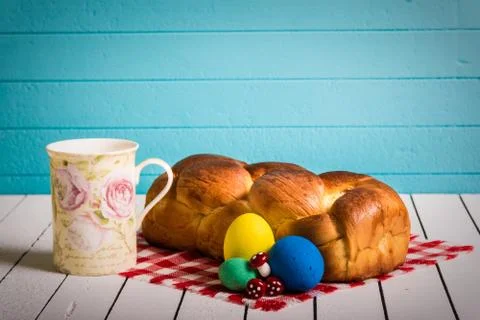 Painted Easter eggs, delicious cake and cup for milk on a wooden background. Eco Stock Photos