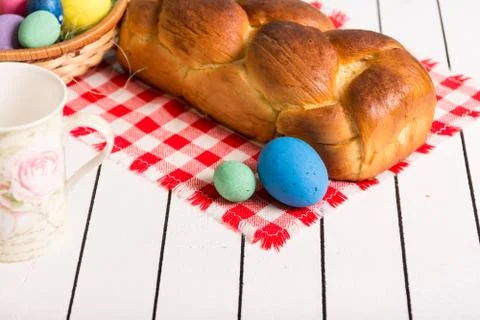 Painted Easter eggs, delicious cake and cup for milk on a wooden background. Eco Stock Photos