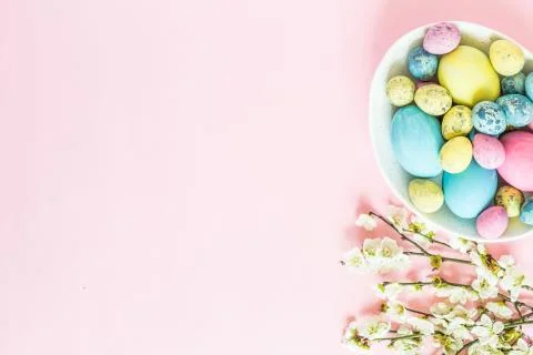 Painted easter eggs, floral branches, nest lying on pink background Stock-Fotos