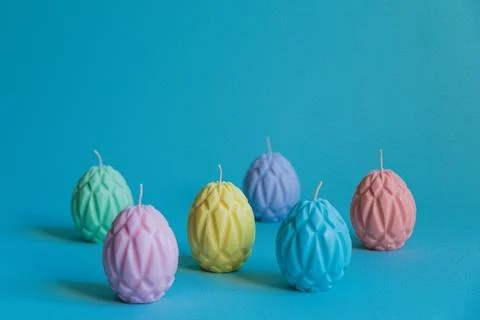 Painted Easter eggs in the form of wax candles are arranged in a checkerboard Stock Photos