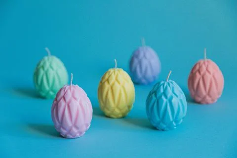 Painted Easter eggs in the form of wax candles are arranged in a checkerboard Stock Photos