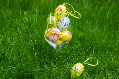 Painted easter eggs in glass on green grass Stock Photos