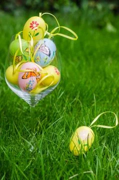 Painted easter eggs in glass on green grass Stock Photos