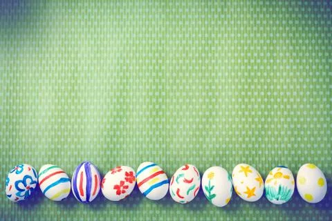 Painted Easter eggs on a green background with white polka dots Stock Photos