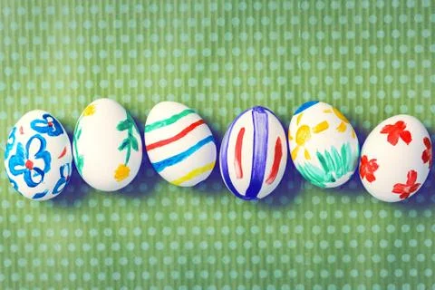 Painted Easter eggs on a green background with white polka dots Foto stock