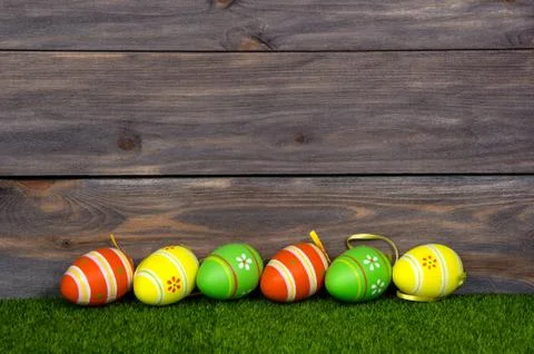 Painted Easter eggs on green grass. Wooden background. Stock Photos
