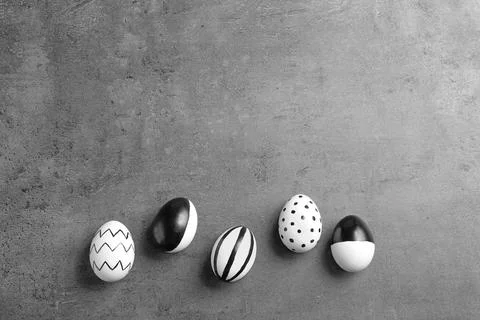 Painted Easter eggs on grey background, flat lay with space for text Stock Photos