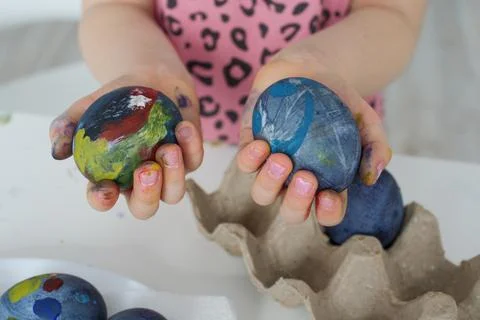Painted Easter eggs in the hands of a child girl close-up. Easter concept Stock Photos