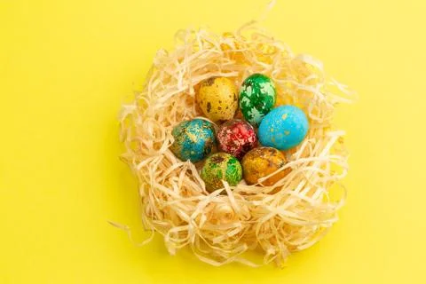 Painted easter eggs lie in a nest of shavings. Stock Photos