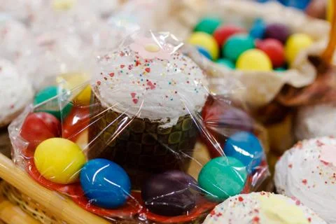 Painted Easter eggs lie in a wicker basket along with a festive Easter cake. Foto stock