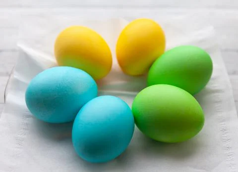 Painted Easter eggs on light wooden background, top view Stock Photos