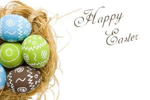 Painted Easter eggs in nest isolated on white background Stock Photos