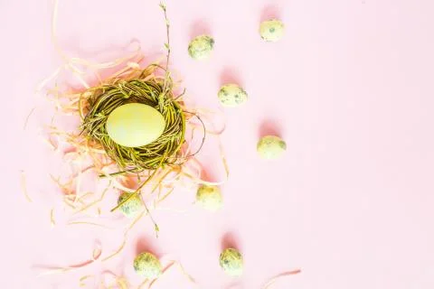 Painted easter eggs in nest lying on pink background Stock Photos