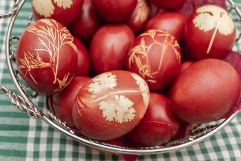 Painted Easter eggs in onion husks with abstract drawings are in a basket Stock Photos
