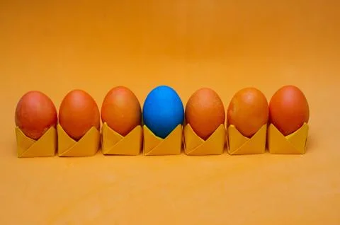 Painted easter eggs on origami stands in a row. Easter concept Stock Photos