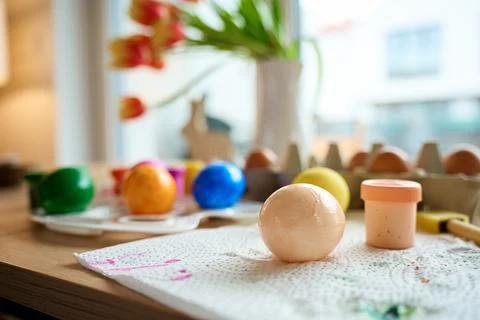 Painted Easter eggs with paints and palette on wooden table Stock Photos