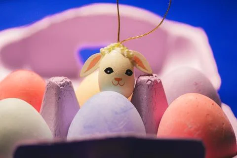 Painted Easter eggs in a pink box on Easter table. Cute toy rabbit Spring decor Stock Photos