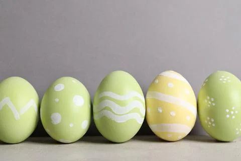 Painted Easter eggs on table against color background, space for text Stock Photos