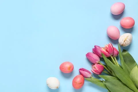 Painted Easter eggs with tulip flowers on blue background Stock Photos