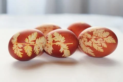 Painted Easter eggs on a white background. Floral pattern on a red eggshell. Stock Photos