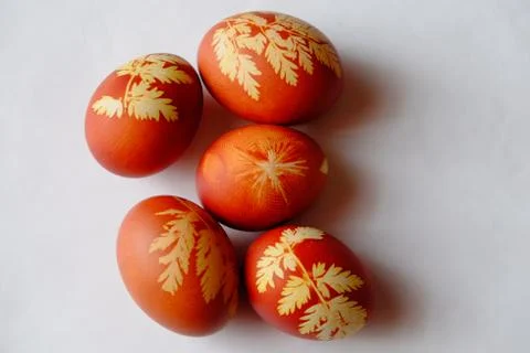 Painted Easter eggs on a white background. Floral pattern on a red eggshell. Stock Photos