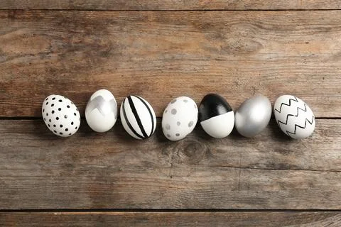 Painted Easter eggs on wooden background, flat lay Stock Photos