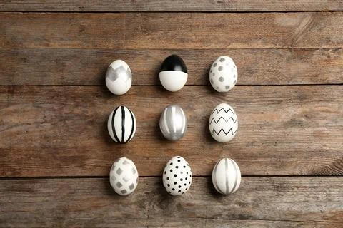 Painted Easter eggs on wooden background, flat lay Stock Photos