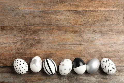 Painted Easter eggs on wooden background, flat lay with space for text 스톡 사진