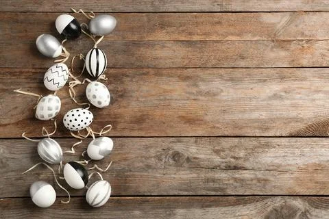 Painted Easter eggs on wooden background, flat lay with space for text Foto stock