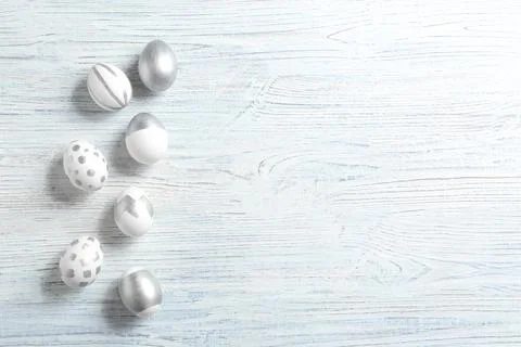 Painted Easter eggs on wooden background, flat lay with space for text Stock Photos