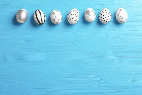 Painted Easter eggs on wooden background, flat lay with space for text Stock Photos