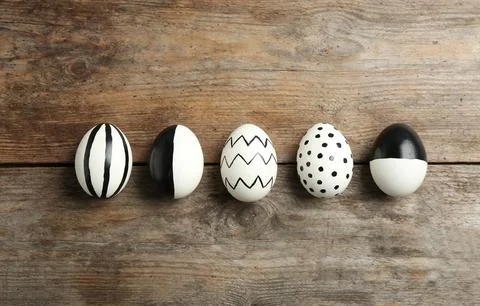 Painted Easter eggs on wooden background, flat lay Stock Photos