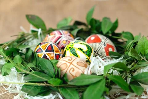 Painted Easter eggs in a wreath of green leaves. Ukrainian traditions. Happ.. Stock Photos