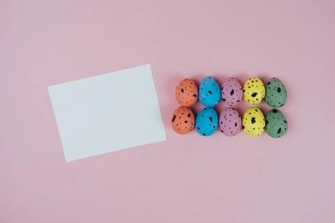 Painted Easter quail eggs and blank greeting card isolated on pink background Stock Photos