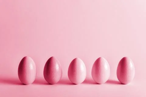 Painted eggs of delicate tones stand on a pale blue background. Stock Photos