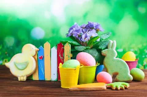 Painted eggs, Easter gingerbreads and primrose flower on wooden background Stock Photos