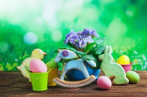 Painted eggs, Easter gingerbreads and primrose flower on wooden background Stock Photos