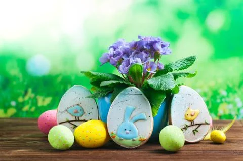 Painted eggs, Easter gingerbreads and primrose flower on wooden background Stock Photos