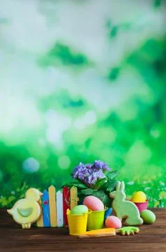 Painted eggs, Easter gingerbreads and primrose flower on wooden background Stock Photos