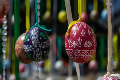 Painted eggs hang from the branches of the Easter tree. The focus is on a yel Stock Photos