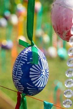 Painted eggs hang from the branches of the Easter tree. The focus is on a yel Stock Photos