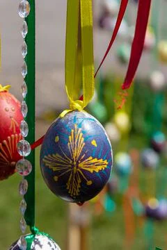 Painted eggs hang from the branches of the Easter tree. The focus is on a yel Stock Photos