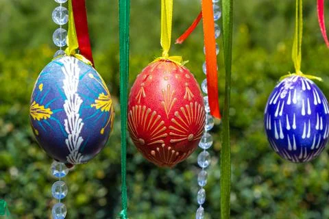 Painted eggs hang from the branches of the Easter tree. The focus is on a yel Stock Photos
