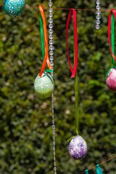 Painted eggs hang from the branches of the Easter tree. The focus is on a yel Stock Photos