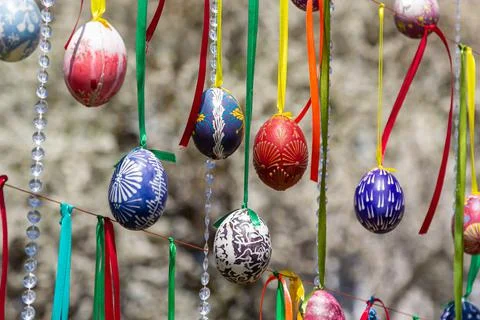 Painted eggs hang from the branches of the Easter tree. The focus is on a yel Stock Photos