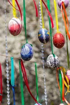 Painted eggs hang from the branches of the Easter tree. The focus is on a yel Stock Photos